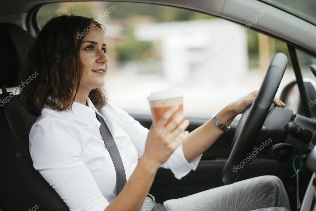 Young woman in car. Businesswoman driving car.