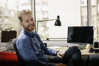 Ofiste çalışan bir iş adamı. Kızıl adam işyerinde oturuyor..