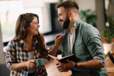 Tasarımcı, ortaklarına proje hakkında yeni fikirler veriyor. İş adamları ofiste yeni iş projelerini tartışıyor.