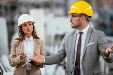 İşadamı ve işkadını fabrikadaki yeni iş projesini tartışıyor