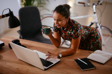 Ofiste bilgisayarla çalışan güzel genç bir iş kadını.