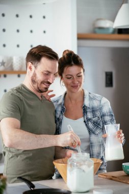 Çift evde birlikte yemek pişiriyor ve yemek hazırlıyor.