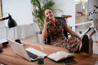 Ofisteki telefonu kullanan mutlu genç iş kadını..