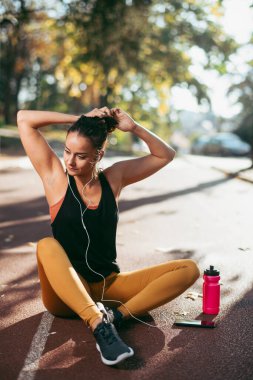 Genç bir kadın dışarıda egzersiz yapıyor. 