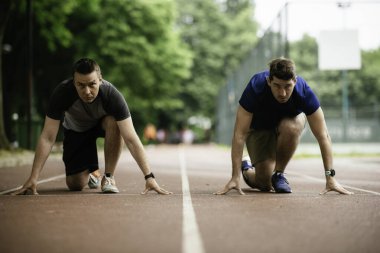 Spor giyimli sporcular koşmak için başlangıç pozisyonunda. Kapat..
