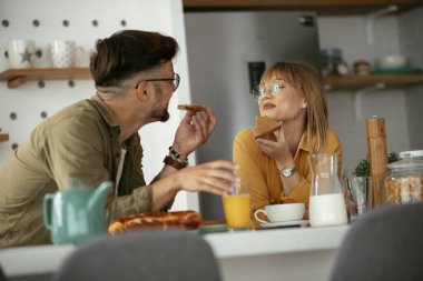 Genç çift evde lezzetli yemekler yapıyor. Sevgi dolu çift mutfakta eğleniyor..