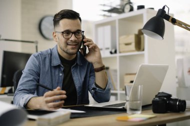 Ofis masasında oturan genç iş adamı