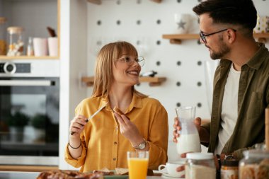 Genç çift evde lezzetli yemekler yapıyor. Sevgi dolu çift mutfakta eğleniyor..