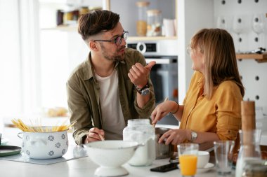 Karı koca mutfakta. Genç çift evde lezzetli yemekler hazırlıyor..