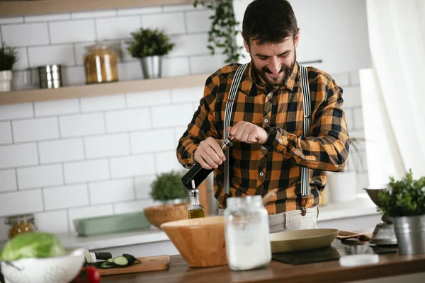 Mutfaktaki yakışıklı adamın portresi. Genç adam lezzetli yemekler hazırlıyor..