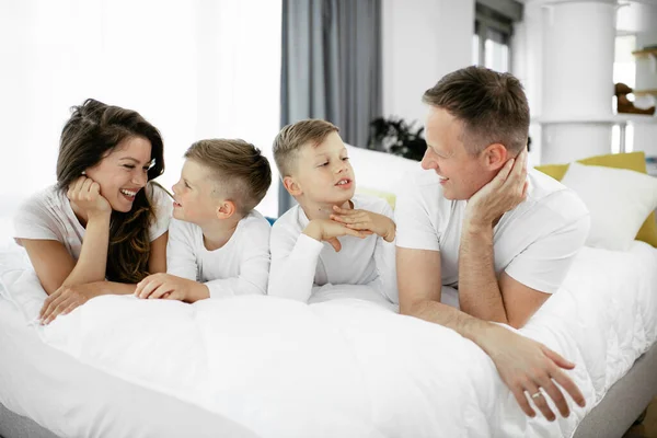 Młoda Rodzina Bawi Się Łóżku Szczęśliwi Rodzice Synami Relaksującymi Się — Zdjęcie stockowe