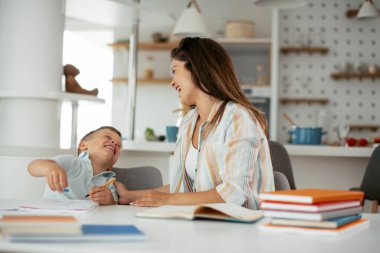 Anne oğluyla ödev yapıyor.