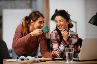 Açık uzay ofisinde konuşan ve gülen mutlu iş kadınları