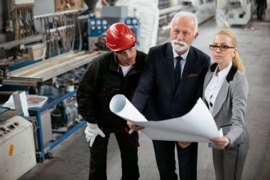 Mimarlar ve işçiler yeni projeyi planlarıyla tartışıyorlar. Fabrikada çalışan meslektaşlar..