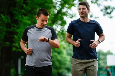 Parkta basketbol oynayan iki genç adam. Arkadaşlar dışarıda dostça bir maç yapıyor.