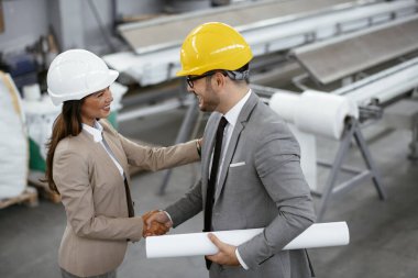 İşadamı ve işkadını fabrikadaki yeni iş projesini tartışıyor