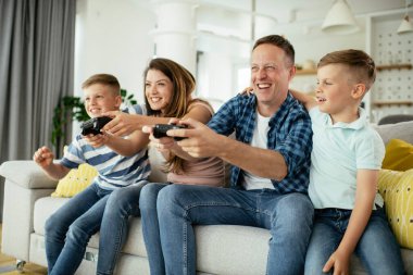  Mutlu çift evde çocuklarla video oyunu oynuyor..