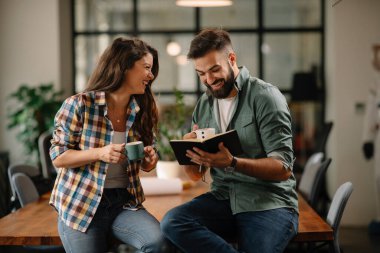 Tasarımcı, ortaklarına proje hakkında yeni fikirler veriyor. İş adamları ofiste yeni iş projelerini tartışıyor.