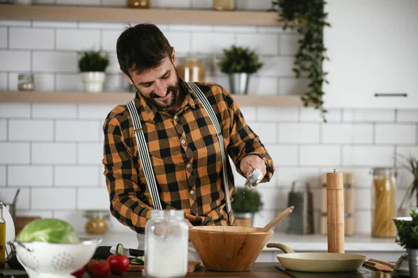 Portrait of handsome man in kitchen. Young man preparing delicious food.