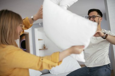 Mutlu çift evde yastıklarla kavga ediyor. 