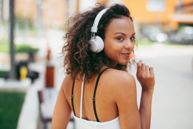 Dışarıdaki genç Afrikalı kadın. Parkta müzik dinleyen güzel bir kadın.