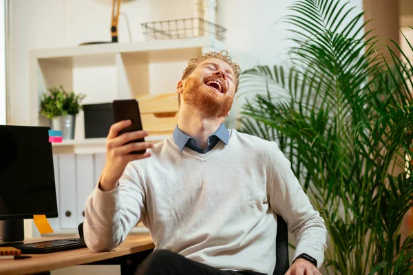 Genç kızıl işadamı telefonda gülerken