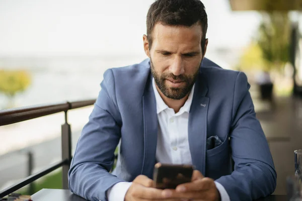 Joven Hombre Negocios Escribir Mensaje Texto Teléfono Inteligente Mientras Trabaja —  Fotos de Stock