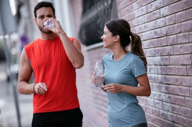 Atletik çift şehirde koştuktan sonra dinleniyor. Mutlu çift sabahları eğleniyor...