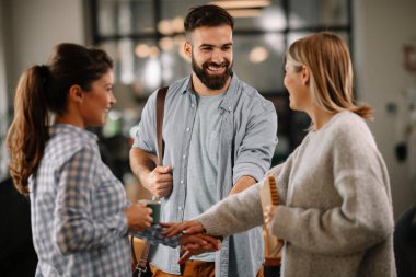 Modern açık uzay ofisinde sıradan iş adamlarından oluşan bir grup. İş kadınları ve işadamları yeni proje hakkında konuşuyor.