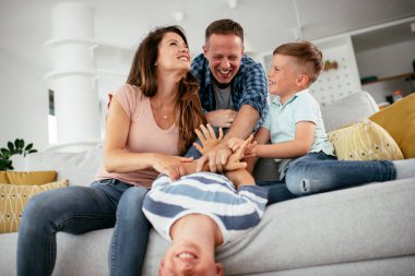 Genç bir aile evde eğleniyor. Mutlu ebeveynler ve çocuklar eğleniyor..