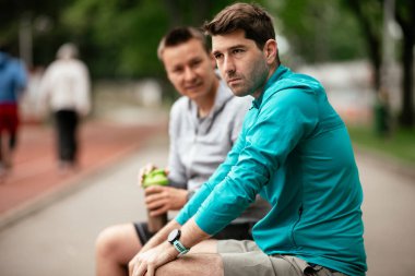 Koşmaktan istirahat eden zinde genç adamlar. Dışarıda antrenman yapan iki arkadaş..