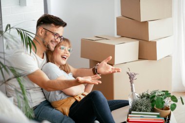 Evde kutuların yanında kucaklaşan çift.