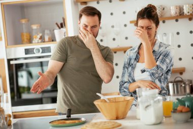 Çift evde birlikte yemek pişiriyor ve yemek hazırlıyor.
