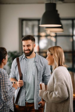 Modern açık uzay ofisinde sıradan iş adamlarından oluşan bir grup. İş kadınları ve işadamları yeni proje hakkında konuşuyor.