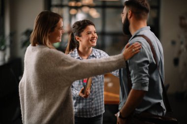Modern açık uzay ofisinde sıradan iş adamlarından oluşan bir grup. İş kadınları ve işadamları yeni proje hakkında konuşuyor.