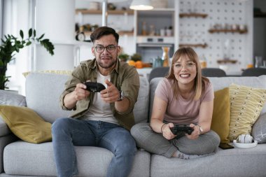 Çift evdeki kanepede oyun oynuyor.