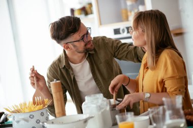 Karı koca mutfakta. Genç çift evde lezzetli yemekler hazırlıyor..