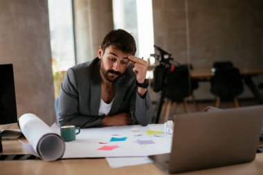 İş adamı proje üzerinde çalışıyor. Ofiste çalışan genç bir işadamı..