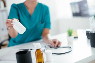 Hastanedeki muayenehanedeki genç bayan doktor.