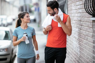 Atletik çift şehirde koştuktan sonra dinleniyor. Mutlu çift sabahları eğleniyor...