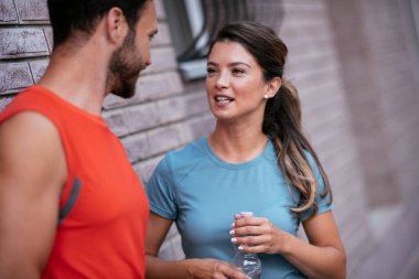 Atletik çift şehirde koştuktan sonra dinleniyor. Mutlu çift sabahları eğleniyor...