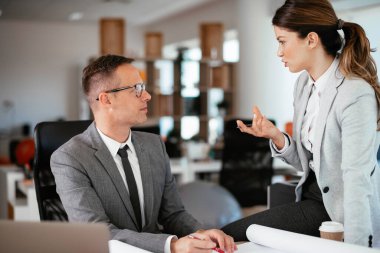 Ofiste birlikte çalışan meslektaşlar. Genç iş kadını ve işadamı yeni projede birlikte çalışıyorlar.