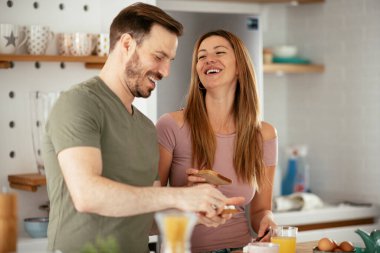 Genç çift evde sandviç yapıyor. Sevgi dolu çift mutfakta eğleniyor..