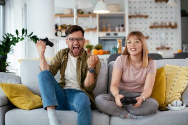 Çift evdeki kanepede oyun oynuyor.