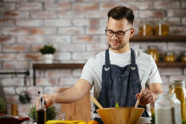 Mutfakta makarna hazırlayan yakışıklı adam. Lezzetli yemek pişiren adam..