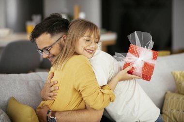 Erkek, kadına hediyesini sunar.