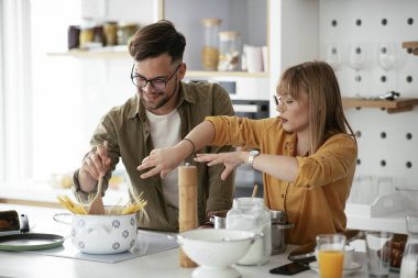 Karı koca mutfakta. Genç çift evde lezzetli yemekler hazırlıyor..