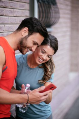 Atletik çift şehirde koştuktan sonra dinleniyor. Mutlu çift sabahları eğleniyor...