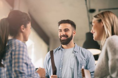 Modern açık uzay ofisinde sıradan iş adamlarından oluşan bir grup. İş kadınları ve işadamları yeni proje hakkında konuşuyor.
