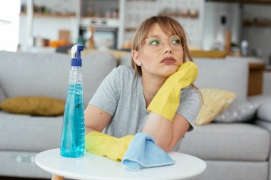 Evini temizleyen üzgün kadın. Evde yorgun bir kadın var..